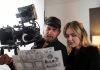 Bearded videographer and his blond female assistant discussing documents